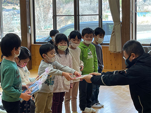 小友保育所への寄贈。園児へ絵本を手渡す様子