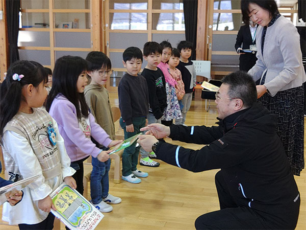 気仙保育所への寄贈。園児へ絵本を手渡す様子